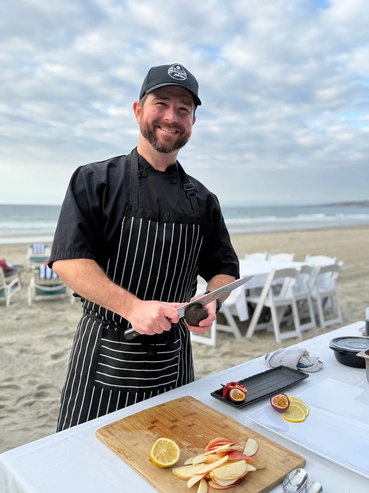 Private chef Matt Brophy prepping fresh fruit on the beach in San Diego