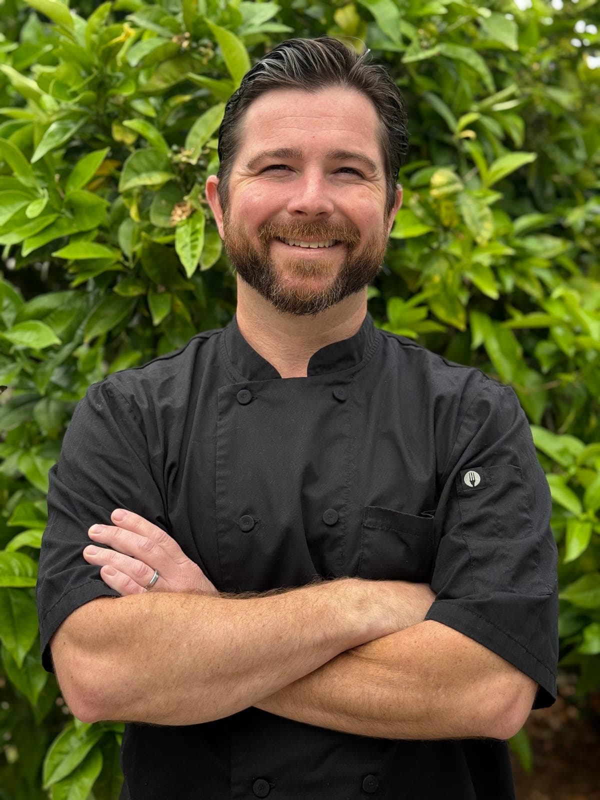 Portrait of private chef Matt Brophy in a black chef coat